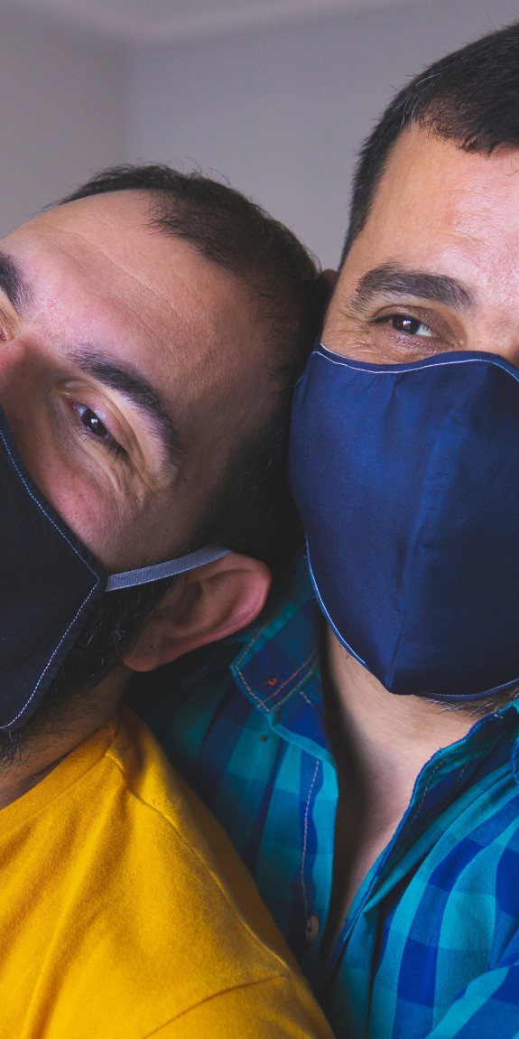 Older couple hugging wearing masks